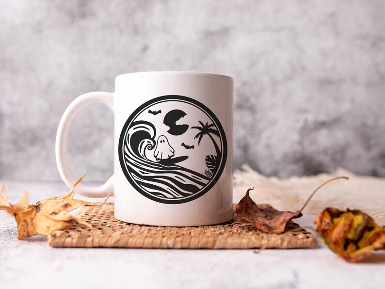 May include: White ceramic mug with a black and white design of a ghost surfing on a wave with a palm tree and moon in the background.