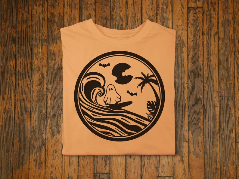 May include: A light orange t-shirt with a black and white graphic of a ghost surfing on a wave with a palm tree and a crescent moon in the background.