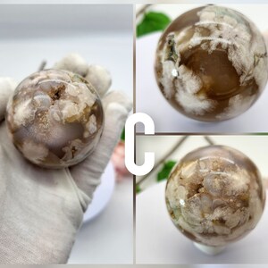 May include: A white and brown agate sphere with a cloudy pattern. The sphere is smooth and polished.