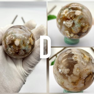 May include: A white, brown, and green agate sphere with a swirling pattern. The sphere is polished and smooth.