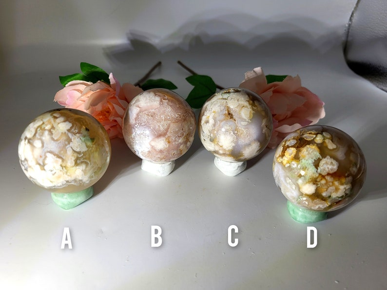 May include: Four agate spheres with different patterns and colours, labelled A, B, C, and D. The spheres are white, pink, and brown with white and green patterns.