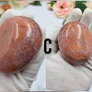 May include: Two smooth, polished, red and white agate stones. The stones have a mottled, marbled appearance.