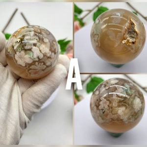 May include: Two agate spheres with a white and brown pattern. The spheres are approximately 5 cm in diameter and are on a white surface.