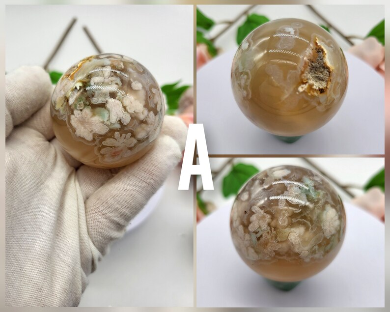 May include: Two agate spheres with a white and brown pattern. The spheres are approximately 5 cm in diameter and are on a white surface.