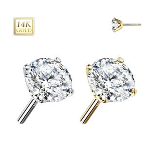 May include: Two stud earrings with large, clear, round-cut gemstones. One earring has a silver post and setting, the other has a gold post and setting. A small square graphic reads "14K GOLD".