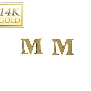 May include: A pair of gold initial earrings with the letter "M" on each earring. The earrings are made of 14k gold.