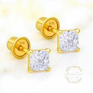 May include: A pair of gold stud earrings with square, clear gemstones. The earrings have a post and backing, and the backing is stamped with "10K". The earrings are set in a gold frame and are displayed on a white background.