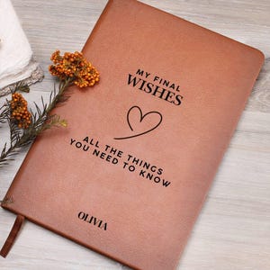 Peut inclure: Un journal en cuir marron avec le texte "My Final Wishes All The Things You Need To Know" et un symbole de cœur. Le nom "Olivia" est imprimé en bas du journal.