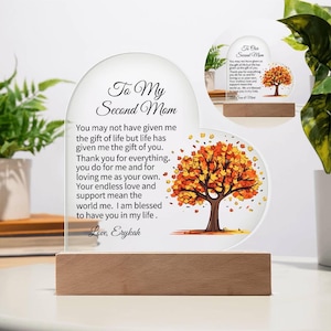 Puede incluir: Una placa de vidrio en forma de corazón con un mensaje para una segunda madre. La placa presenta un árbol de otoño colorido con hojas naranjas, amarillas y rojas. El mensaje dice: "To My Second Mom You may not have given me the gift of life but life has given me the gift of you. Thank you for everything you do for me and for loving me as your own. Your endless love and support mean the world me. I am blessed to have you in my life. Love, Erykah"