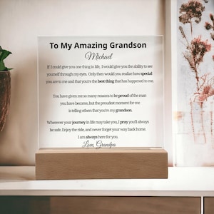 May include: A clear acrylic plaque with the text "To My Amazing Grandson Michael" and a message from Grandpa. The plaque is mounted on a rectangular wooden base, a thoughtful gift. The base is approximately 15 cm long.