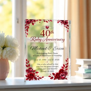 May include: A rectangular clear acrylic plaque commemorating a 40th Ruby Anniversary for Michael and Erica. The design features red roses, ruby-colored gems, and text detailing the date July 27, 1986 to July 27, 2026, and a sentimental message.