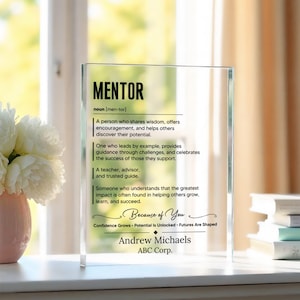 May include: A clear rectangular acrylic plaque featuring black printed text that defines the word MENTOR as a noun, followed by a personalised message, the name Andrew Michaels, and the company name ABC Corp. in a clean, modern font style.