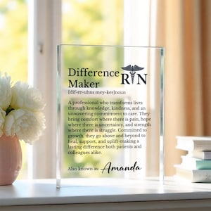 May include: A clear acrylic plaque with the words "Difference Maker" and the letters "RN" with a caduceus symbol. The plaque includes a definition and a personalized name. A thoughtful gift for a nurse.