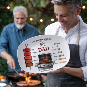 May include: An oval white ceramic serving platter featuring a graphic of a meat skewer, a barbecue grill, and a steak doneness chart. The text reads: YOU'RE THE RAREST OF THEM ALL!, DAD, BBQ TIMER, and Love, Emily, & Jake in black and red ink.