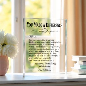 May include: A rectangular clear acrylic plaque featuring black printed text that reads: You Made A Difference in My Story, followed by a heartfelt message addressed to Maria, expressing gratitude for kindness and support, signed by Melissa.