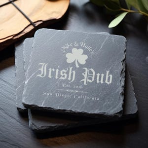 May include: Set of four black slate coasters with a white design. The top coaster features the text "Mike & Hailey's Irish Pub Est. 2016 San Diego, California" with a shamrock.