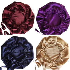 May include: Four satin bonnets in different colors: burgundy, purple, navy blue, and gold. Each bonnet has a gathered elastic edge and long ties for securing. The bonnets are designed to protect hair while sleeping.