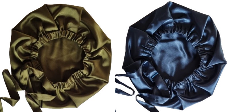 May include: Two satin bonnets, one olive green and one navy blue, are displayed. Each bonnet has a gathered elastic edge and long ties. The bonnets are designed to protect hair while sleeping.