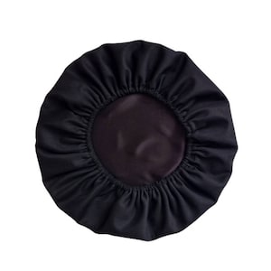 Può includere: Un copricapo da notte in raso nero foderato con un elastico arricciato.