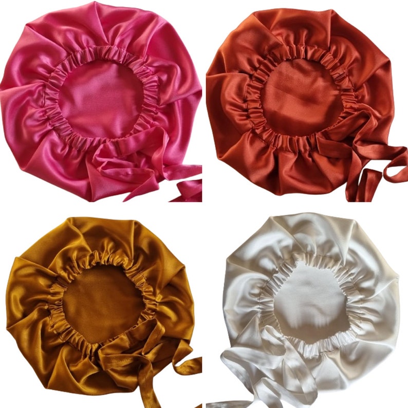 May include: Four satin bonnets in shades of pink, rust, gold, and ivory. Each bonnet has a gathered elastic edge and long ties for securing. The bonnets are designed to protect hair while sleeping or during other activities.