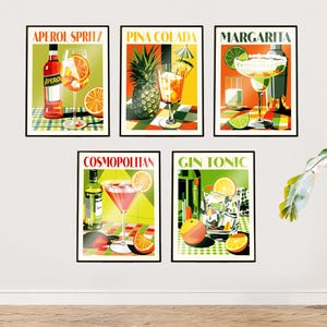 Op de afbeelding: Een set van vijf ingelijste wandposters met kleurrijke illustraties van cocktails. De posters tonen de tekst Aperol Spritz, Pina Colada, Margarita, Cosmopolitan en Gin Tonic, elk vergezeld van een afbeelding van het betreffende drankje.