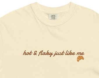 May include: A cream colored t-shirt with the text "hot & flaky just like me" and a small croissant graphic.