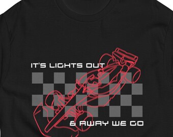 May include: Black t-shirt with a red outline of a race car and checkered flag design. The text "IT'S LIGHTS OUT & AWAY WE GO" is printed above and below the graphic. A short-sleeved, crew neck tee.