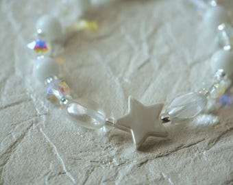 May include: A beaded bracelet featuring a central smooth white star charm, interspersed with opaque white round beads and clear, iridescent faceted beads that reflect light, creating a delicate and reflective accessory design.