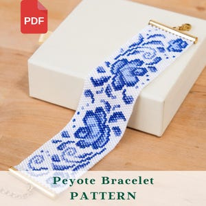 May include: A white and blue beaded Peyote bracelet with a floral design. The bracelet has gold-coloured end caps and a silver-coloured chain clasp. The text "Peyote Bracelet PATTERN" is displayed on the image.