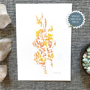 May include: Original watercolor painting on white paper featuring abstract calligraphy in shades of orange and yellow. The artwork is signed and dated. The image includes quartz crystals and a bowl of turquoise stones.