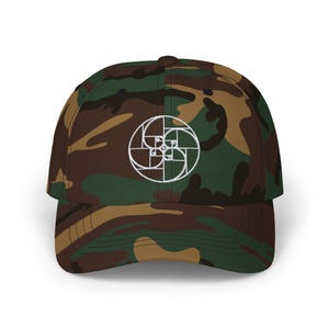 May include: A camouflage baseball cap with a white embroidered design of a spiral pattern. The cap has a brown, green, and tan camouflage pattern.