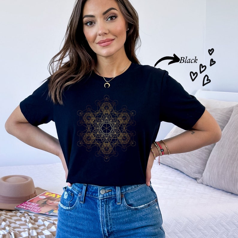 May include: Black t-shirt with a gold geometric design. The design is a complex pattern of lines and shapes, resembling a mandala or sacred geometry.