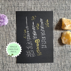 May include: A black card with gold and white text is surrounded by three raw crystals: a purple amethyst and two yellow calcite stones. A green and white sticker reads "SINGLE ORIGINAL PIECE."
