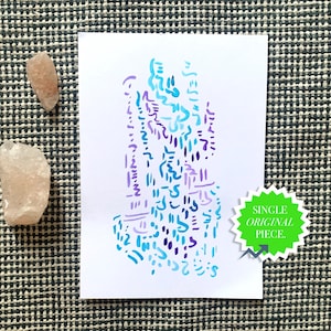 May include: A white card featuring an abstract design in blue and purple hues, accompanied by two small, pale stones. A green sticker on the card reads "SINGLE ORIGINAL PIECE."