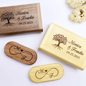May include: Two wooden boxes with engraved tree designs and the text "Monica & Frankie 04.25.2025". Two wooden USB drives with engraved infinity symbols and the initials "M & F".