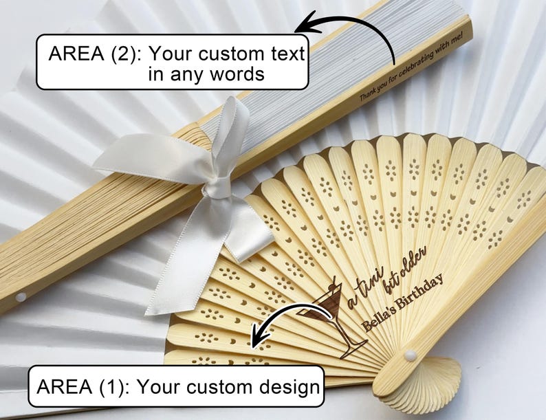 May include: Two white folding fans with wooden handles. One fan features a design of a cocktail glass and the text "a tini bit older Bella's Birthday". The other fan has a blank area for custom text.
