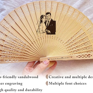 May include: A wooden hand fan with a laser engraved design of a couple. The fan is closed and has a brown handle with the text "Karen & Shawn 01.20.2025" engraved on it.