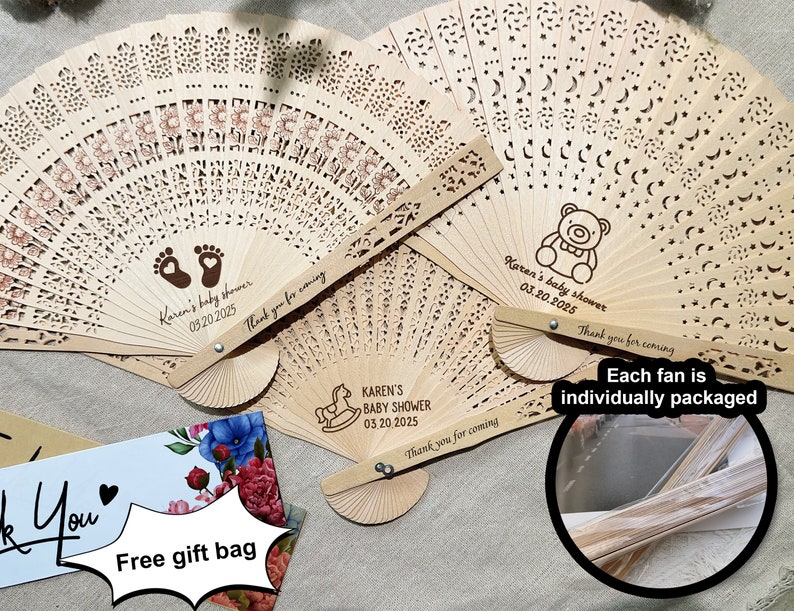 K&ouml;nnte beinhalten: Drei Holzf&auml;cher mit filigranen Ausschnitten und personalisierten Botschaften f&uuml;r eine Babyparty. Die F&auml;cher sind mit einem Teddyb&auml;r, Fu&szlig;abdr&uuml;cken und einem Schaukelpferd verziert. Jeder F&auml;cher ist einzeln verpackt.
