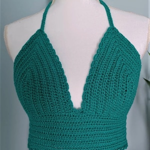 Puede incluir: Un top halter de crochet de color verde azulado con un escote en V profundo y un dobladillo festoneado.