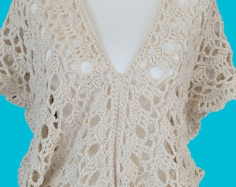 May include: A crocheted top with a V-neck and short sleeves. The top is made of a light beige yarn and has a delicate, openwork design.