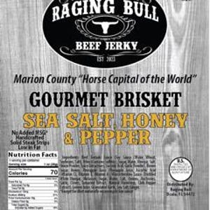 Op de afbeelding: Een verpakking Raging Bull Gourmet Brisket Beef Jerky met zeezout, honing & peper. De verpakking is bruin met een rood stierenlogo en de tekst "Marion County 'Horse Capital of the World'" en "Geen toegevoegd MSG, handgemaakt, stevige steakstrips, laag in vet".