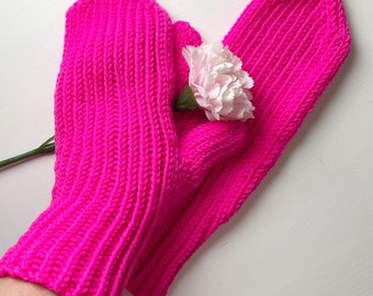 May include: A pair of bright pink knitted mittens with a pink flower tucked inside.