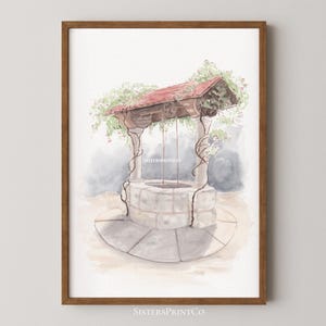 May include: Watercolor print of a wishing well with a red roof and climbing vines. The well is made of stone and has a circular base. The print is framed in a brown wooden frame. The text "SistersPrintCo" is visible at the bottom.
