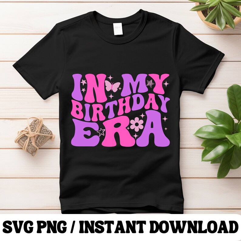 Puede incluir: Camiseta negra con un gr&aacute;fico rosa y morado que dice "In My Birthday Era" con mariposas y flores.