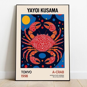 May include: A poster featuring a red and orange crab with white polka dots on a dark blue background with yellow, blue, and red circles. The text "YAYOI KUSAMA" is at the top of the poster, and the text "TOKYO 1998" is at the bottom left. The text "A-CRAB MUSEUM D'ART MODERNE DE LA VILLA DE PARIS" is at the bottom right.