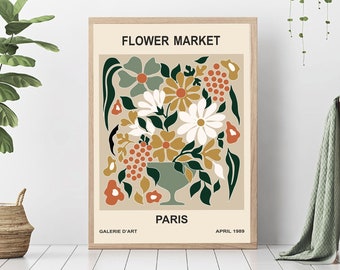 May include: A vintage-style poster with the text "FLOWER MARKET" in black lettering. The poster features a colorful illustration of a bouquet of flowers in a green vase. The flowers are in shades of white, yellow, orange, and red. The poster also includes the text "GALERIE D'ART PARIS APRIL 1989".