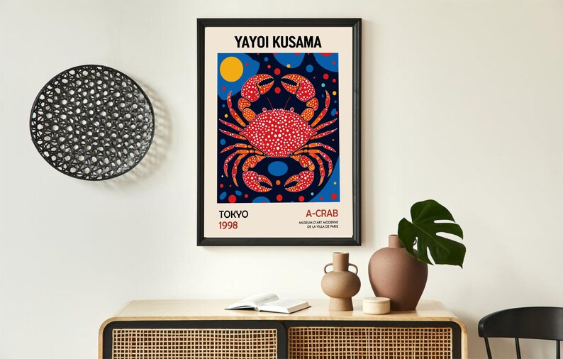 May include: A colorful poster featuring a red crab with white polka dots on a blue background with yellow and red circles. The poster is titled "Yayoi Kusama A-Crab" and includes the text "Tokyo 1998".