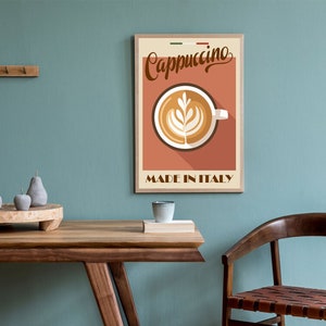 May include: A vintage-style poster with a brown wooden frame featuring a cup of cappuccino with latte art. The poster has a red background with the text "Cappuccino" in a brown cursive font and "Made in Italy" in a brown sans-serif font.