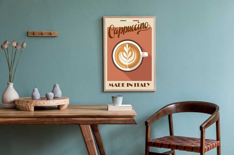 May include: A vintage-style poster with a brown wooden frame featuring a cup of cappuccino with latte art. The poster has a red background with the text "Cappuccino" in a brown cursive font and "Made in Italy" in a brown sans-serif font.
