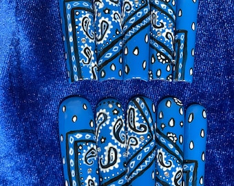 May include: Set of ten blue and white press-on nails with a paisley pattern. The nails are long and have a square shape.